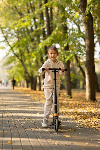 Mädchen, das einen Roller im Park fährt