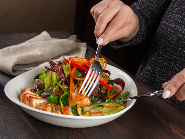 Foto mädchen, das einen salat der hühnerbrust und des frischen gemüses isst