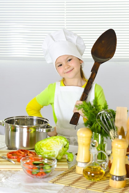 Mädchen, das einheitliches Kochen des Chefs trägt