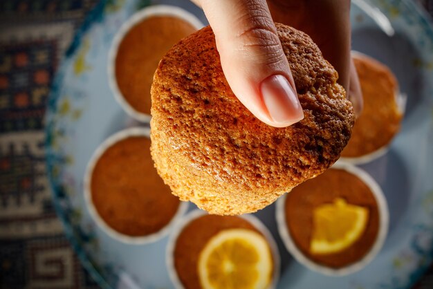 Mädchen, das frischen kleinen Kuchen in ihrer Hand hält.