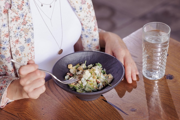 Mädchen, das gesunde Salatnahaufnahme in einem modernen Restaurant isst