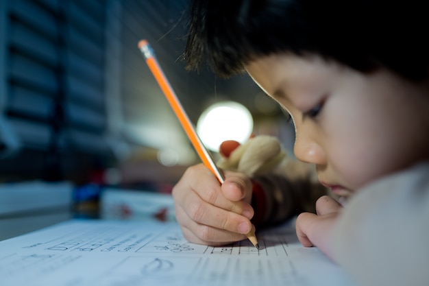 Mädchen, das Hausaufgaben macht, Kind, das Papier schreibt, Bildungskonzept, zurück zur Schule