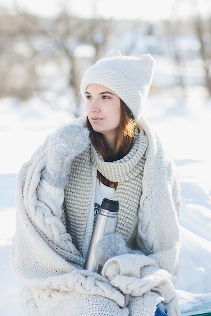 Mädchen, das heißen Tee von einer Thermosflasche trinkt