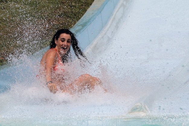 Mädchen, das hinuntergeht und die Wasserrutsche im Wasserpark genießt?