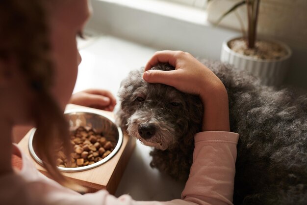 Mädchen, das Hund streichelt und füttert