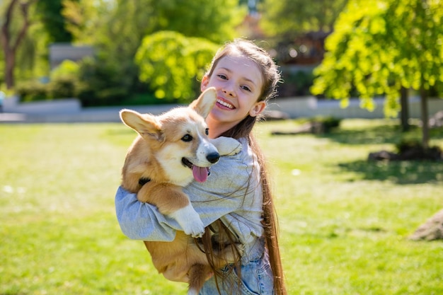 Mädchen, das ihren Corgiwelpen in ihren Armen hält