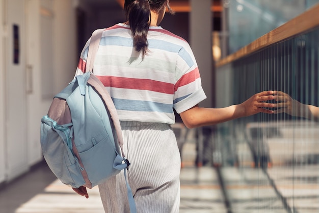 Mädchen, das im Sonnenlicht zur Schule geht