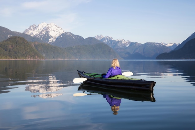 Mädchen, das in einem See Kajak fährt