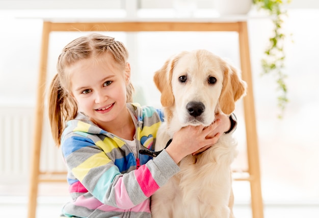 Mädchen, das jungen Hund umarmt