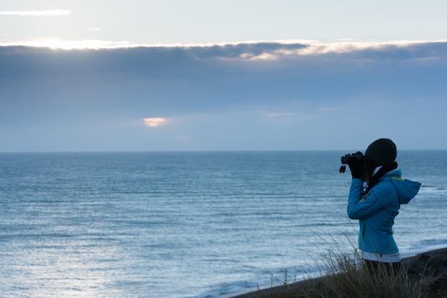 Mädchen, das Meer mit Ferngläsern schaut