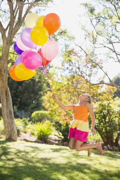 Mädchen, das mit Ballonen im Park spielt
