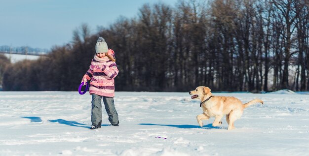 Mädchen, das mit Hund draußen spielt