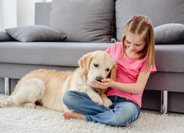 Mädchen, das mit Hund zu Hause spielt