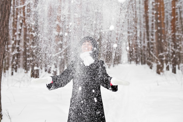 Mädchen, das mit Schnee im Park spielt