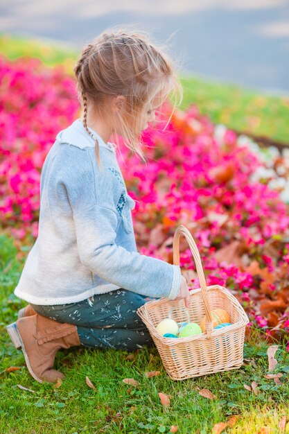 Mädchen, das nach Ostereiern im Gras bei Ostern sucht