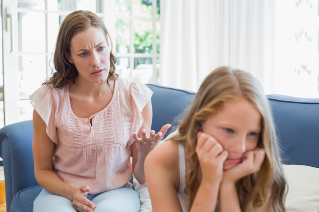 Mädchen, das nicht nach einem Argument mit Mutter im Wohnzimmer spricht