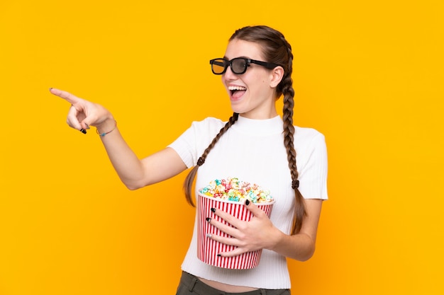 Mädchen, das Popcorn beim Aufpassen eines Films über lokalisierter Wand isst