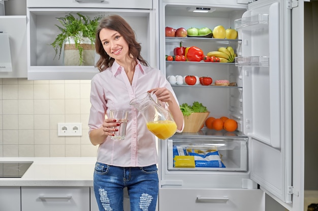 Mädchen, das Saft in Glas gießt