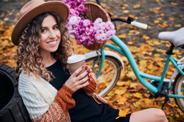 Mädchen, das sich im Herbst im Freien in der Nähe des Fahrrads ausruht