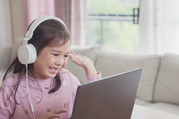 Foto mädchen, das videoanruf mit laptop zu hause macht