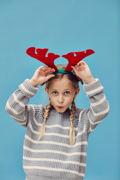 Mädchen, das Weihnachtshirsch vortäuscht