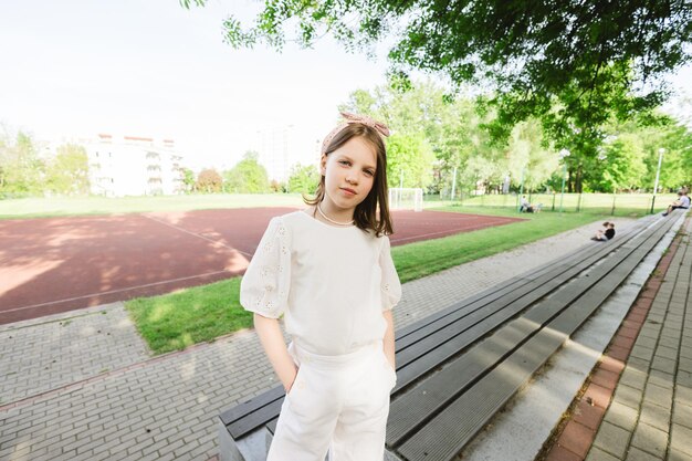 Mädchen, das Zeit allein im Stadtpark verbringt an einem schönen warmen, sonnigen Tag, das Zeit alleine verbringt und die Freiheit in der Natur genießt, friedliche Atmosphäre.