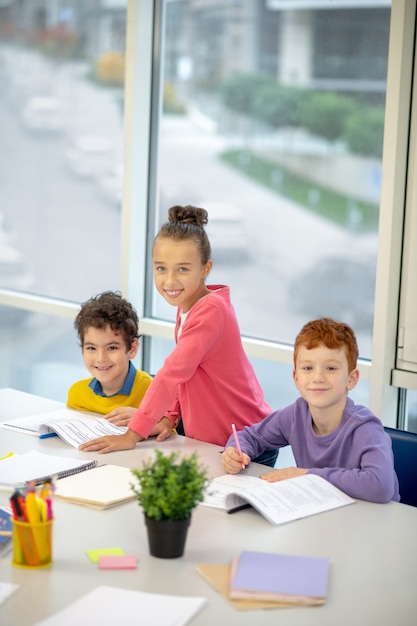 Mädchen, das zwischen Jungen von ihrer Klasse steht