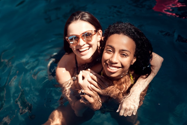 Mädchen, die den bikini genießt, im hotel-pool im freien zu schwimmen tragen