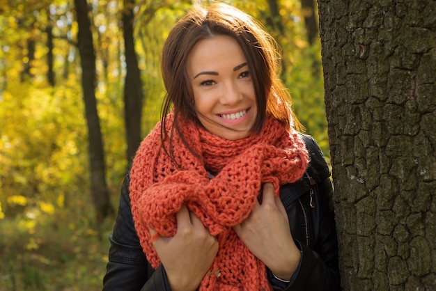 Mädchen, die im Herbstpark stehen und lächeln