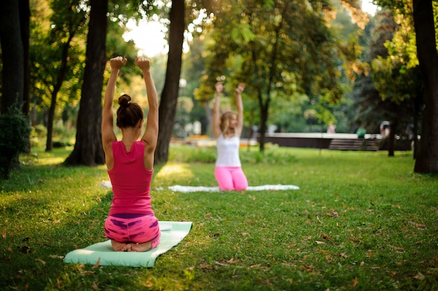 Mädchen, die Yoga im Park in der beruhigenden Haltung üben