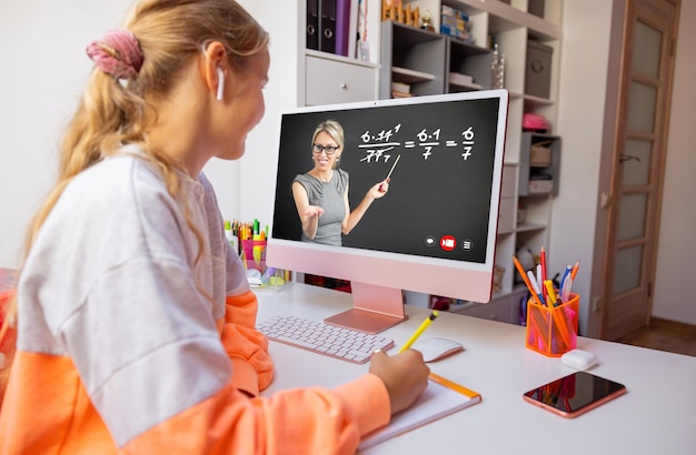 Mädchen, die zu Hause lernen und Online-Kurse auf dem Computer ansehen