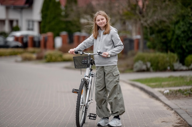 Mädchen fährt im Frühling mit dem Fahrrad zwischen Privathäusern in Europa