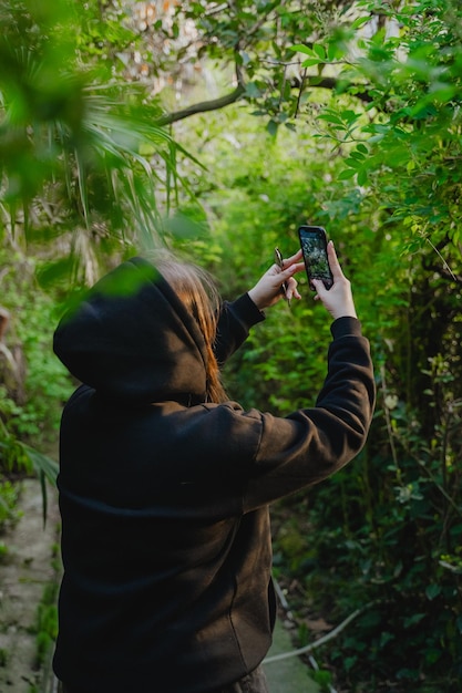 Mädchen filmt auf einem Handy im Park