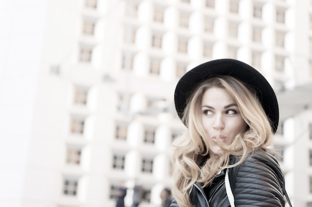 Mädchen flirten mit sinnlichem Gesicht langen Haaren schwarzen Hut in la Defense Paris Fashion Beauty Look