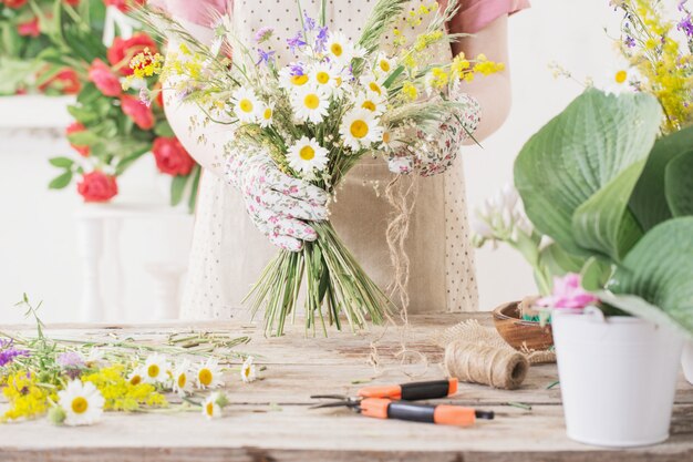 Mädchen Florist macht Blumenstrauß von Wildblumen