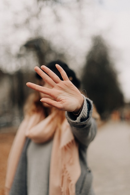 Foto mädchen geht auf die straße und bedeckt ihr gesicht mit ihrer handfläche