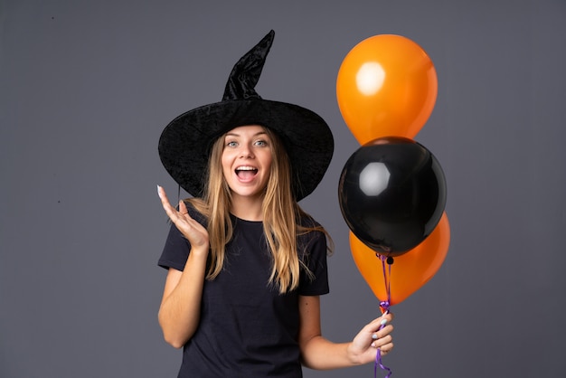 Mädchen gekleidet als Hexe für Halloween, das Überraschungsgeste tut