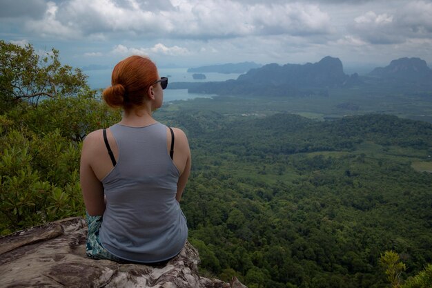 Mädchen genießt vom Aussichtspunkt Krabi Thailand aus einen wunderschönen Blick auf das Tal und die Inseln und Berge der Andamanensee