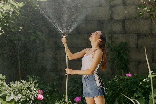 Mädchen genießt Wasser in der Hitze des Sommers im Garten