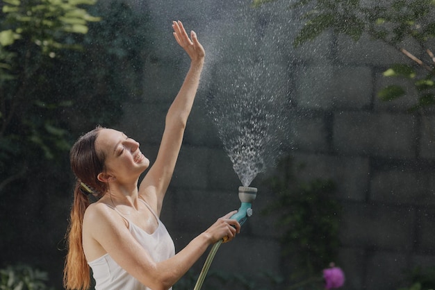 Mädchen genießt Wasser in der Hitze des Sommers im Garten