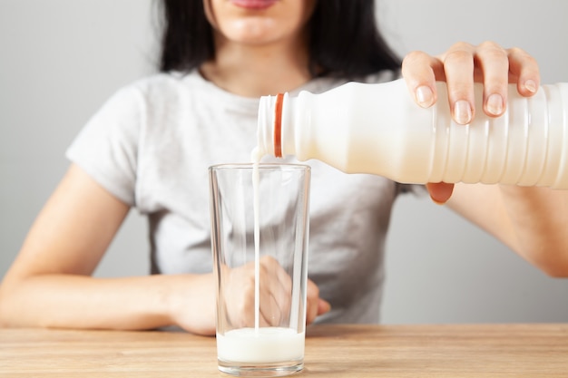 Mädchen gießt Milch in ein Glas