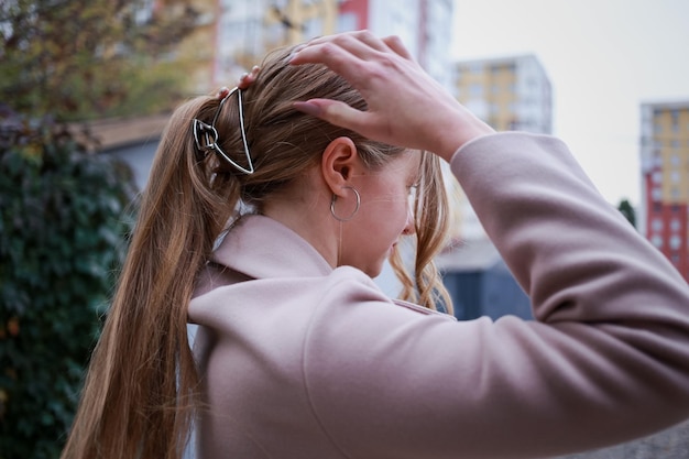 Mädchen glättet ihr Haar mit einer Haarspange mit der Hand