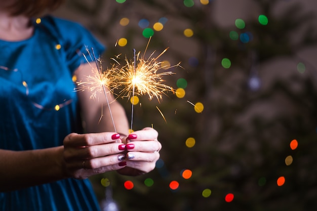 Mädchen hält bengalische Lichter frohe Weihnachten und frohe Feiertage