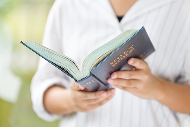 Mädchen hält Bibel in ihren Händen Konzept für Glauben, Religion, Spiritualität, Hoffnung und Frieden