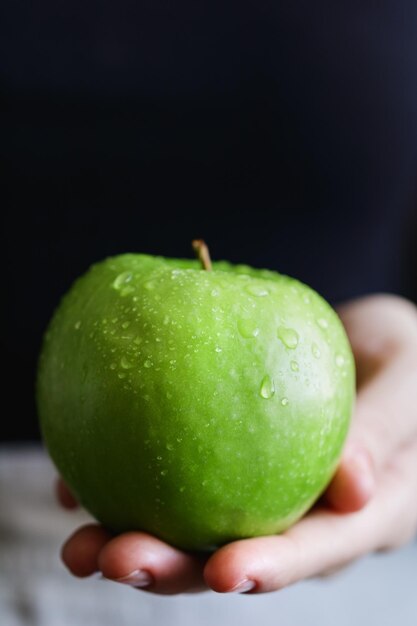 Mädchen hält den frischen grünen Apfel in einer Hand Das Konzept von Bio-Lebensmitteln und Ernte