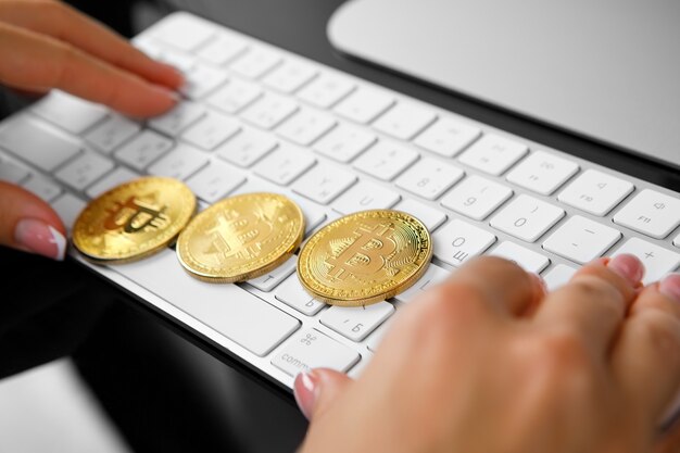 Foto mädchen hält eine krypta in bitcoin seine hand auf einem laptop-hintergrund