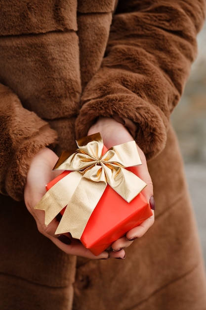 Mädchen hält eine Schachtel mit einem Geschenk in der Hand Nahaufnahme Das Konzept für den Valentinstag