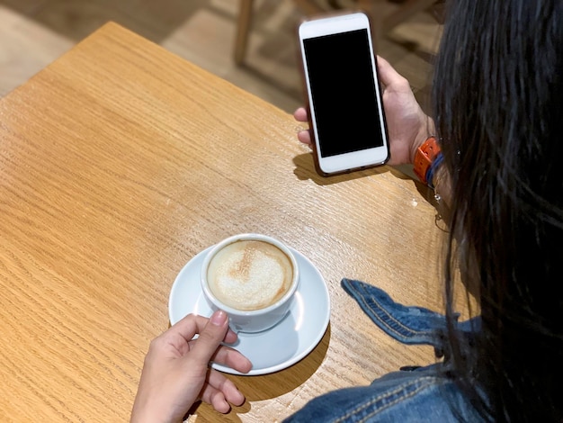 Mädchen hält eine Tasse Kaffee auf einem Holztisch im Café Panama City Mittelamerika