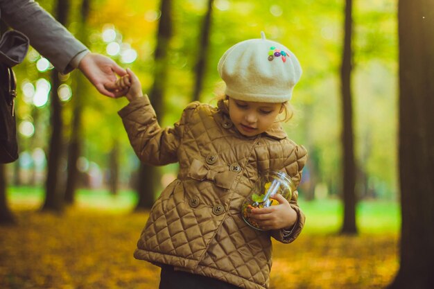 Mädchen hält Flasche gefüllte Herbstschätze