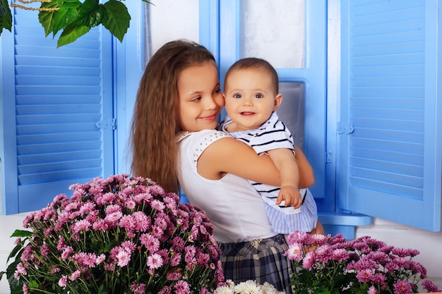 Mädchen hält in Händen kleine Schwester. Das Konzept der Kindheit